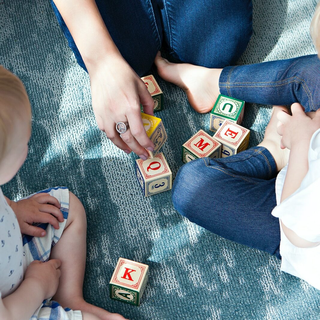 two toddler playing letter cubes